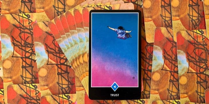 carta tarot zen osho confian�a � um homem caindo do ceu sem nada segurando de bra�os aberto em um ceu azul e rosa.