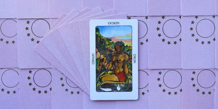 oxum uma mulher negra semi nua sentada no ch�o com uma bandana e um colar em formato de cora��o.
