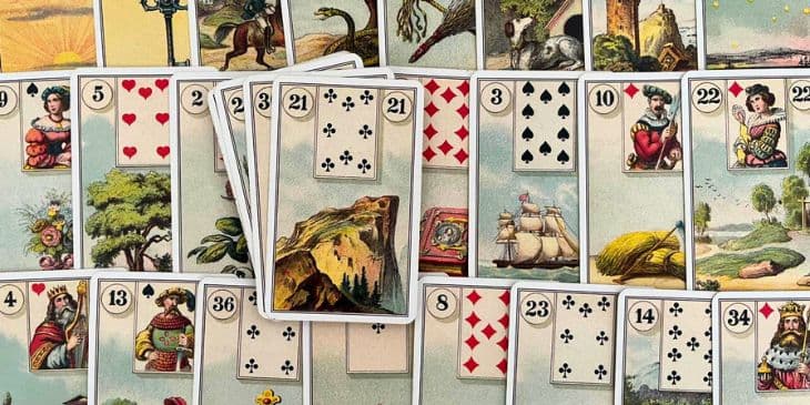 Varias cartas do Baralho Cigano abertas em uma mesa com as imagens das cartas para cima.