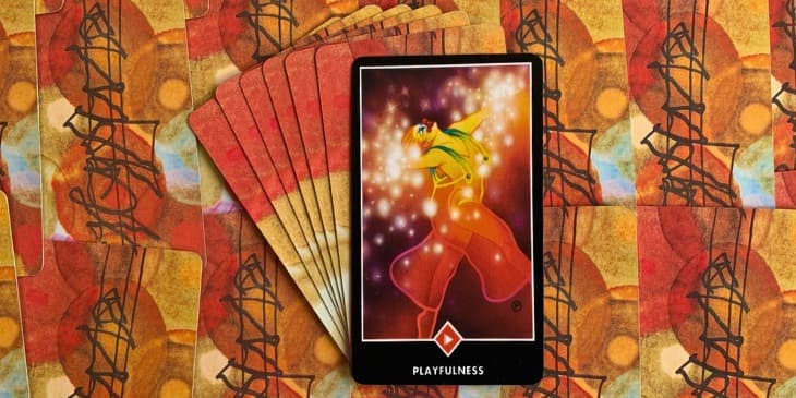 A figura feminina na carta, em plena celebra��o da vida, � uma met�fora para a metamorfose e o renascimento, semelhante � borboleta que se liberta da cris�lida. Este s�mbolo � um convite � transforma��o pessoal, � aceita��o do fluxo cont�nuo da vida e a vivenci�-lo com prazer e leveza. Assim como a borboleta, somos convidados a emergir para uma nova etapa da vida, deixando para tr�s velhos padr�es e paradigmas, acolhendo com entusiasmo as novas possibilidades. A carta tamb�m faz refer�ncia � nossa inf�ncia, uma �poca de nossa vida em que t�nhamos um olhar mais l�dico e menos preocupado com as dificuldades e desafios da vida. A men��o a constru��o de castelos na areia, sem preocupa��o com as ondas que poderiam vir a desmanch�-los, enfatiza a import�ncia de viver o momento, sem ansiedade pelo futuro ou rancor pelo passado. Trata-se de uma celebra��o da imperman�ncia e das constantes mudan�as que a vida apresenta. A figura da mulher vestida de palha�o refor�a a ideia de que a vida n�o deve ser sempre levada t�o a s�rio, sugerindo que o riso e o humor s�o curativos e transformadores. Seu traje leve e transparente reflete a vulnerabilidade, autenticidade e honestidade, qualidades necess�rias para vivenciar a vida de uma maneira mais completa e verdadeira.