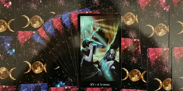 Carta do tarot das bruxas que mostra um casal com medo em um bosque onde no fundo tem uma imagem sombria que esta de preto e causando muito medo.