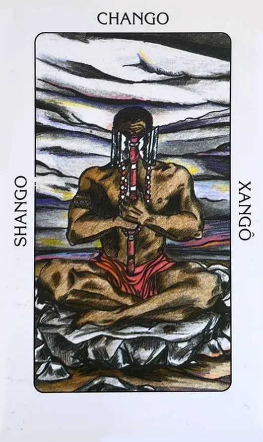 A carta retrata Xang� como um homem forte de ombros largos, sentado sobre uma grande rocha na posi��o de l�tus, ereto como se formasse um �ngulo reto entre suas coxas, quadris e coluna vertebral. Essa postura transmite uma sensa��o de equil�brio, estabilidade, for�a e seguran�a. Suas m�os seguram um de seus principais s�mbolos, o machado de corte duplo com o qual este nobre lutador administra a justi�a, e o mesmo machado cobre seus olhos. Em seu bra�o direito, ostenta uma guia contra eguns, enfeitada com b�zios, que envolve seu pesco�o. Atr�s dele, um c�u nublado descreve com perfei��o o ambiente de influ�ncia deste orix�, tamb�m chamado de 