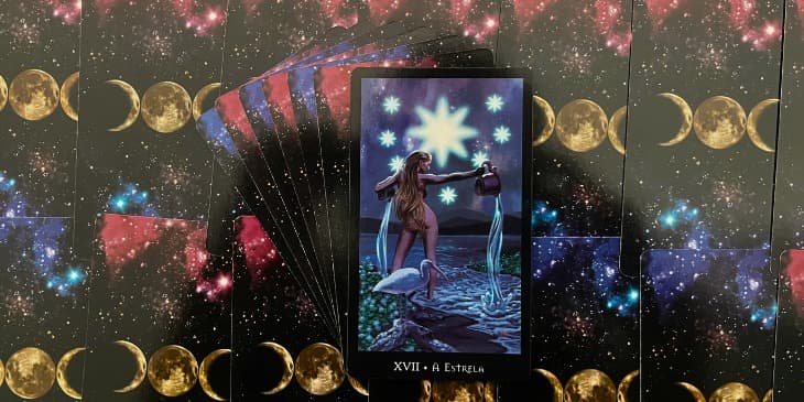 a carta do tarot da bruxa mostra uma mulher nua na beira de um lago na noite segurando um jarro de agua, no ceu tem uma estrela bem grande e outras pequenas e no lado tem um p�ssaro branco.