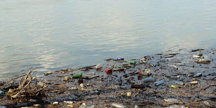 um rio cheio de sujeira e garrafas