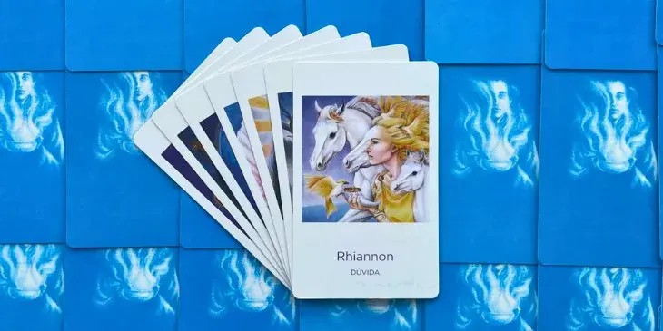 a carta da deusa Rhiannon uma linda mulher loira com 3 cavalos brancos em volta e um passaro tomando agua na sua m�o