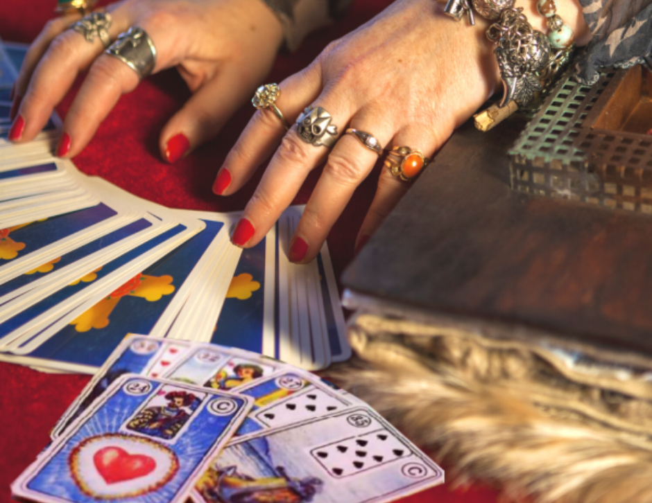 cartomante com as m�os em cima das cartas do baralho cigano