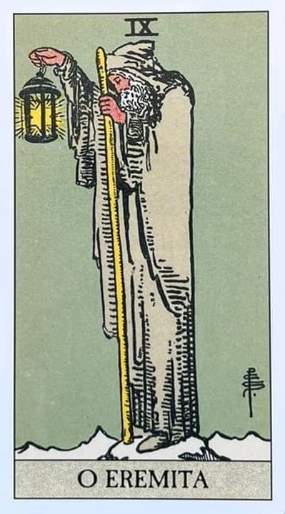 um senhor segurando em uma m�o uma lanterna com uma estrela de seis pontas dentro dela, na outra m�o ele segura um bast�o que vai ate o ch�o. ele usa um manto branco que tem capuz e uma capa.