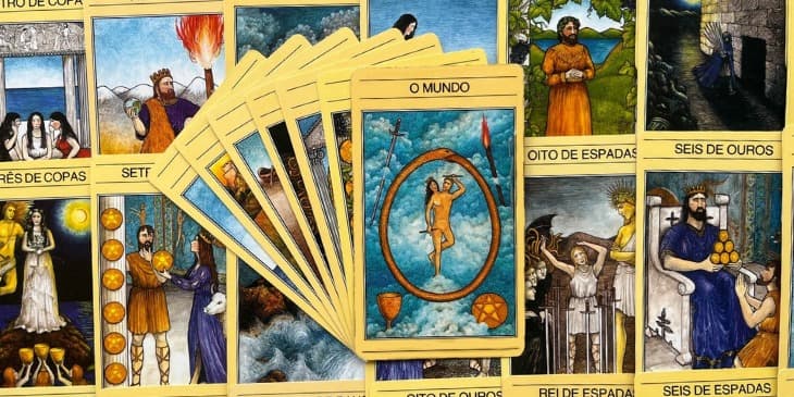 A carta do Mundo retrata uma serpente dourada enrolada na forma de um ovo que come a pr�pria cauda. Dentro do c�rculo, uma estranha figura est� dan�ando, metadehomem e metade mulher, alada, com uma coroa de louros e segurando em cada uma dasm�os uma vara dourada. Em volta da serpente, surgindo das nuvens, um c�lice, uma espada, uma tocha e um pent�culo dourado
