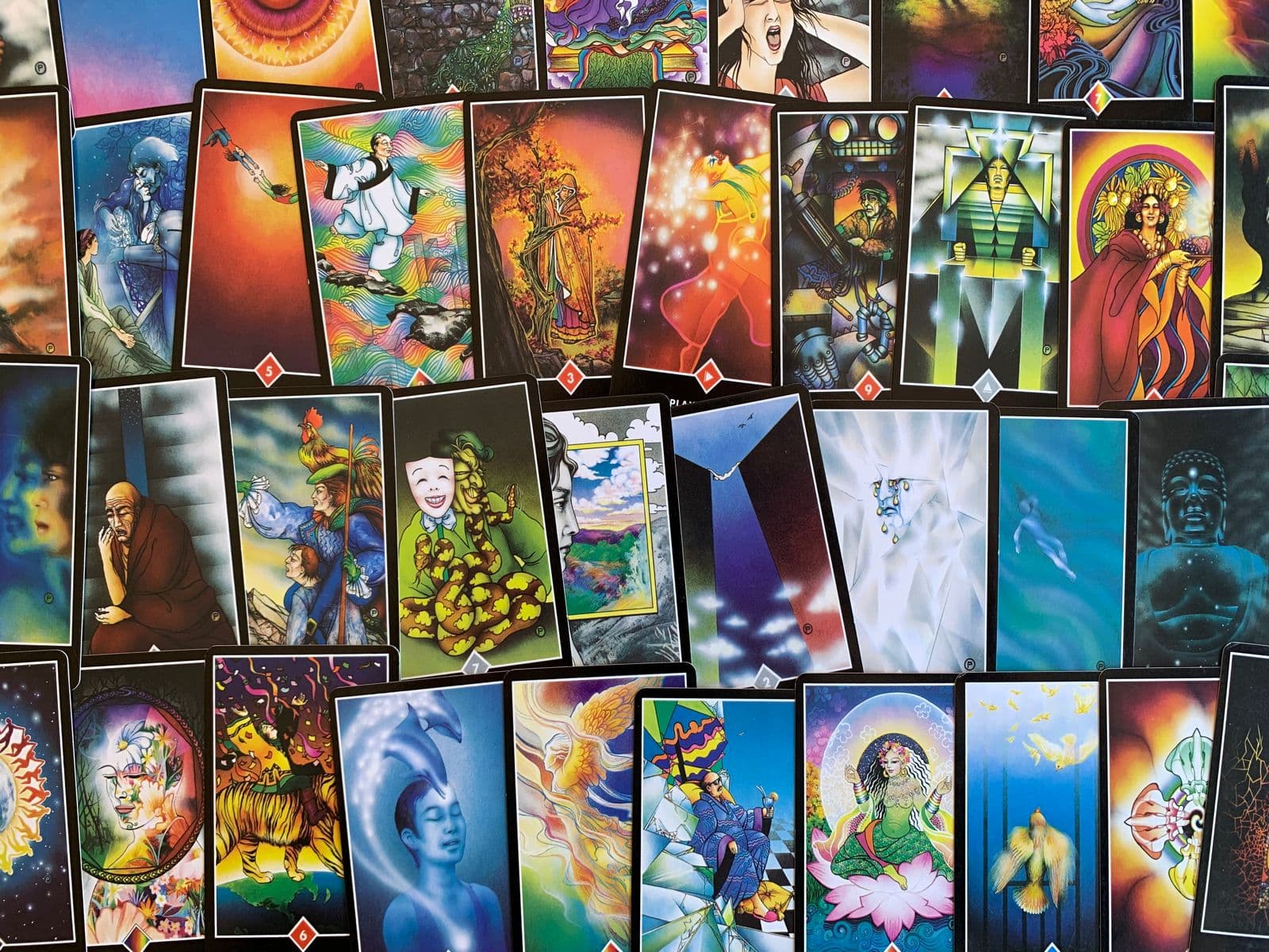 Varias cartas dos Arcanos Menores do Tarot Zen Osho abertas em uma mesa