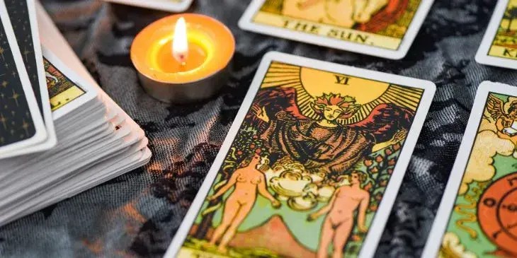cartas do tarot em uma mesa com uma vela do lado