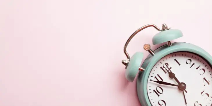 um rel�gio azul em um fundo rosa