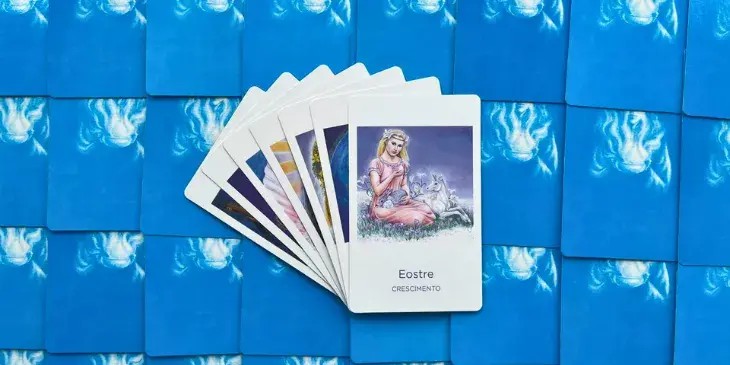 deusa eostre, uma mulher loira sentada na grama com um coelho e um filhote de cavalo branco ao seu lado.