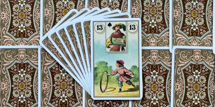 Uma criança com vestimentas antigas brincando com um circulo e uma vara.