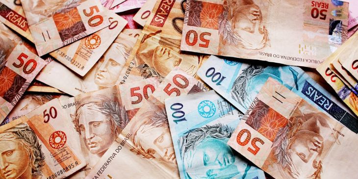 varias notas de reais espalhadas por uma mesa