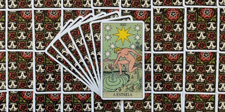 uma mulher ajoelhada �s margens de um pequeno lago ou riacho, vertendo �gua de duas jarras, uma em cada m�o, a mulher esta nua e O cen�rio noturno � iluminado por v�rias estrelas, sendo a mais brilhante de oito pontas, que se destaca no centro da composi��o.