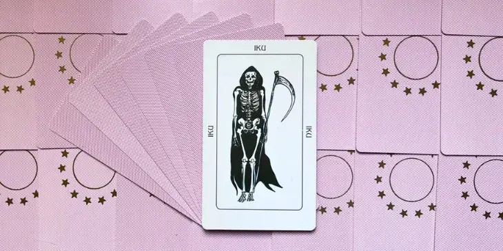 uma caveira com uma capa preta e segurando na m�o uma foice da morte