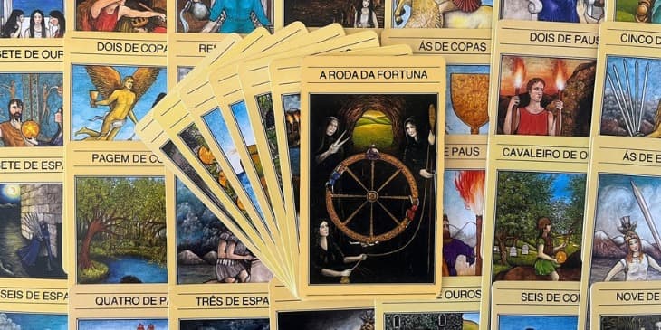 No centro da cena, uma roda dourada exibe quatro figuras humanas em diferentes est�gios da jornada. O verde exuberante al�m da abertura da caverna sugere a vida em seu ciclo eterno. A mensagem � clara: as Moiras urdem o destino, e qualquer tentativa de desafi�-lo resulta em 