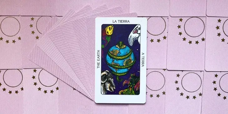a terra abra�ada por uma cobra ou serpente verde, nos cantos da carta tem 4 animais, um peixe colorido, um passaro branco, um bode e um drag�o soltando fogo.