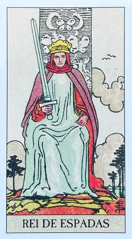 Rei est� retratado sentado em um trono, erguido no alto sob um c�u cinzento e tumultuoso, o que pode representar os desafios e as tempestades que ele enfrenta e supera com sua mente agu�ada. Ele segura uma espada apontada para cima em uma m�o, um s�mbolo cl�ssico de poder e decis�o, indicando sua capacidade de usar a l�gica e o julgamento para cortar atrav�s da confus�o e alcan�ar a verdade. A espada tamb�m sugere a comunica��o clara e objetiva, caracter�sticas essenciais de um l�der eficaz