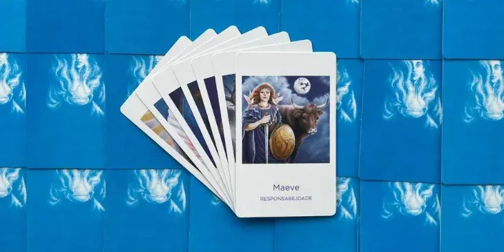 a deusa maeve com sua espada e escudo na m�o, dois passaros brancos no ombro, um vestido azul e uma linda coroa na cabe�a com um boi marrom ao seu lado.