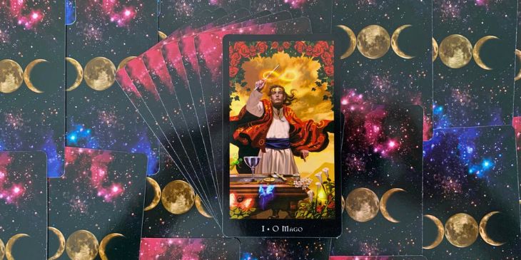 O Mago, principal figura da carta, apresenta-se vestido com um manto vermelho, uma cor intensa que simboliza a energia, a paix�o, a for�a e o poder. A postura ativa dele, de p�, indica a disposi��o para a a��o, para dar in�cio a novos projetos ou empreendimentos. Na m�o direita, o Mago segura uma varinha e desenha no c�u o s�mbolo do infinito, sugerindo a ideia de ciclos infind�veis, da eternidade e da interconex�o entre todas as coisas. A m�o esquerda, com o dedo indicador apontando para a terra, refor�a o conceito de 