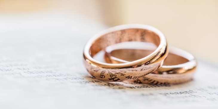 duas alian�as de casamento em cima de um livro.